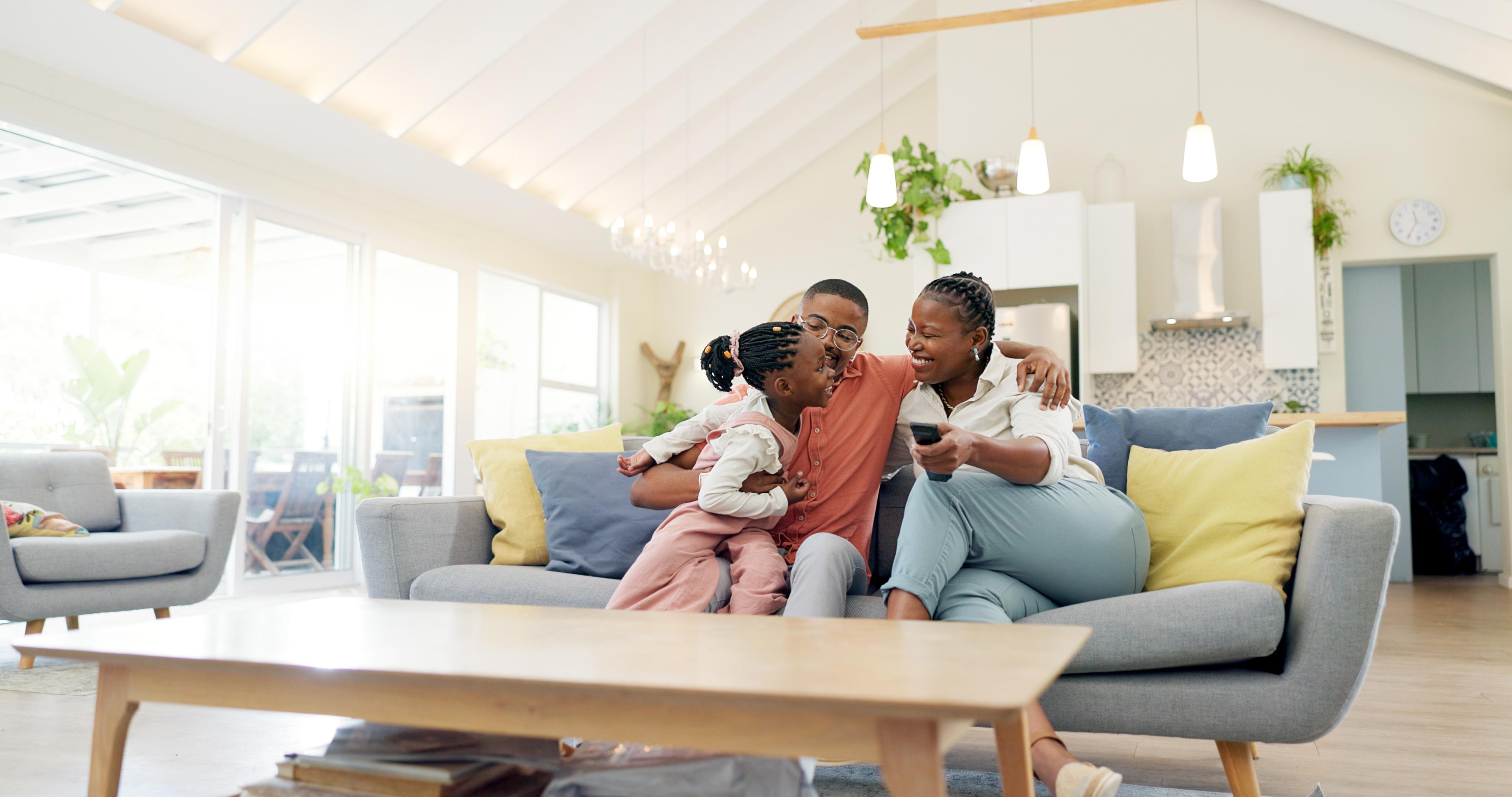 A view of a happy family in a fully furnished living room shows how a family can benefit from using lease-to-own with Acima Leasing.