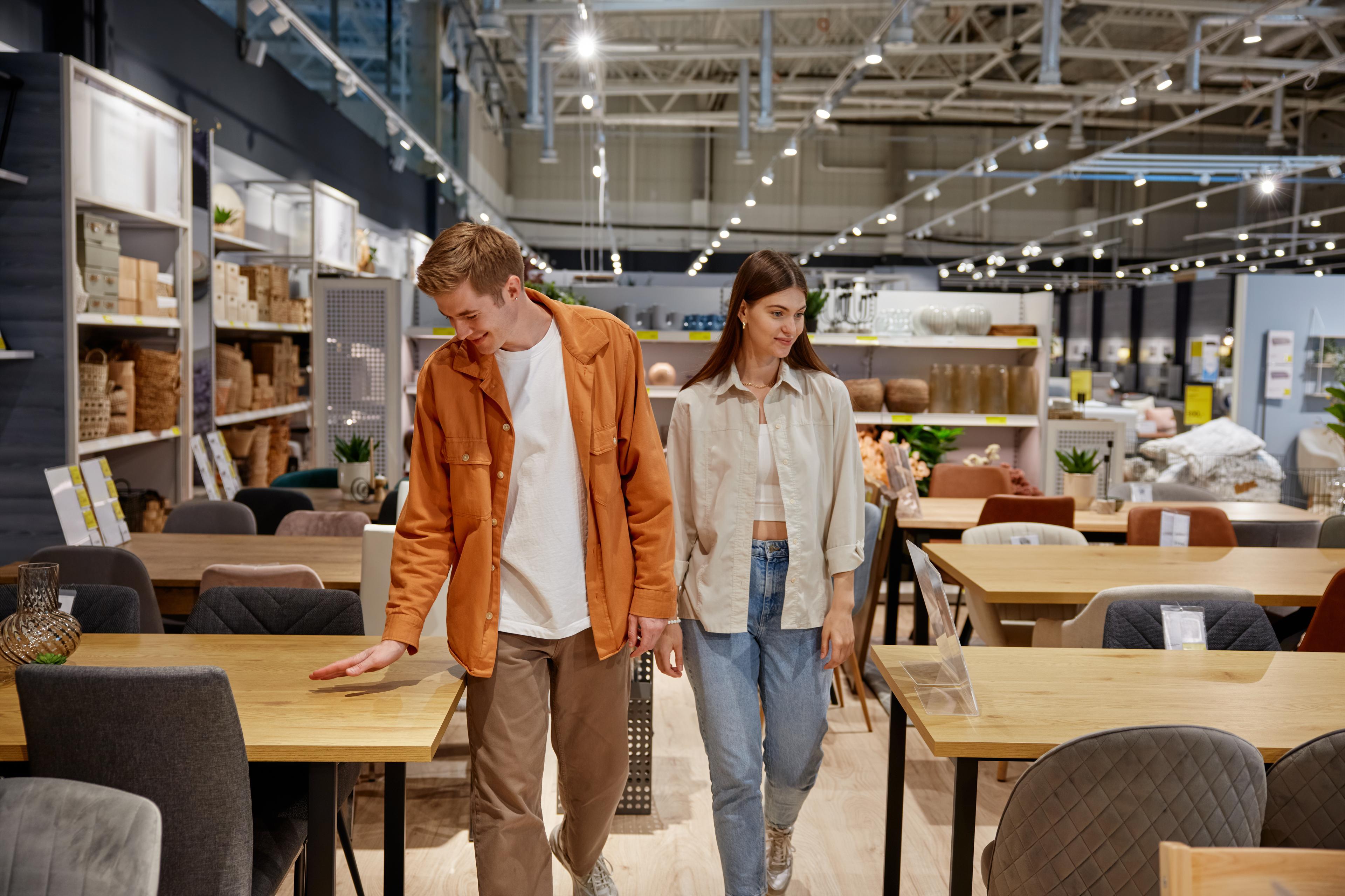 A man and woman shopping in a retail store for furniture shows the ease of using Acima Leasing for home product needs.